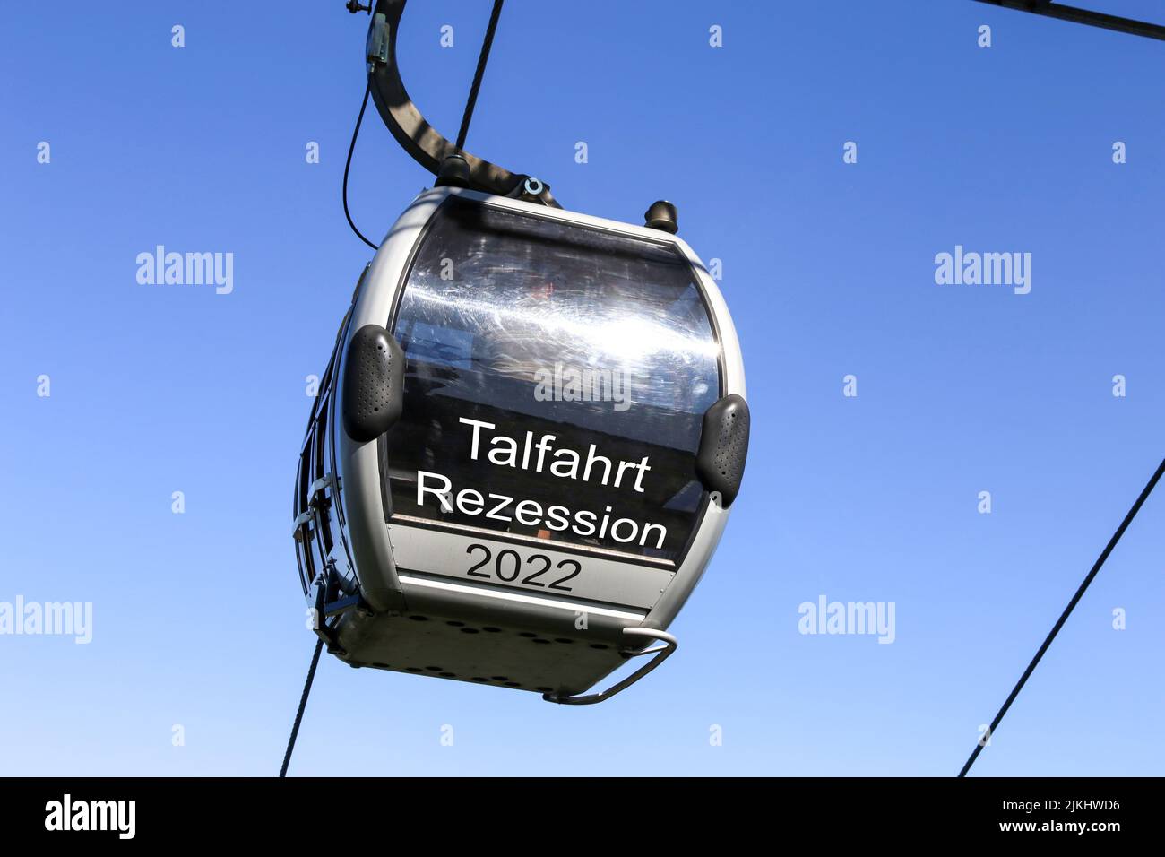 Symbolbild Rezession: Gondel mit der Aufschrift Talfahrt, Rezession vor blauem Himmel (Composing) Stock Photo