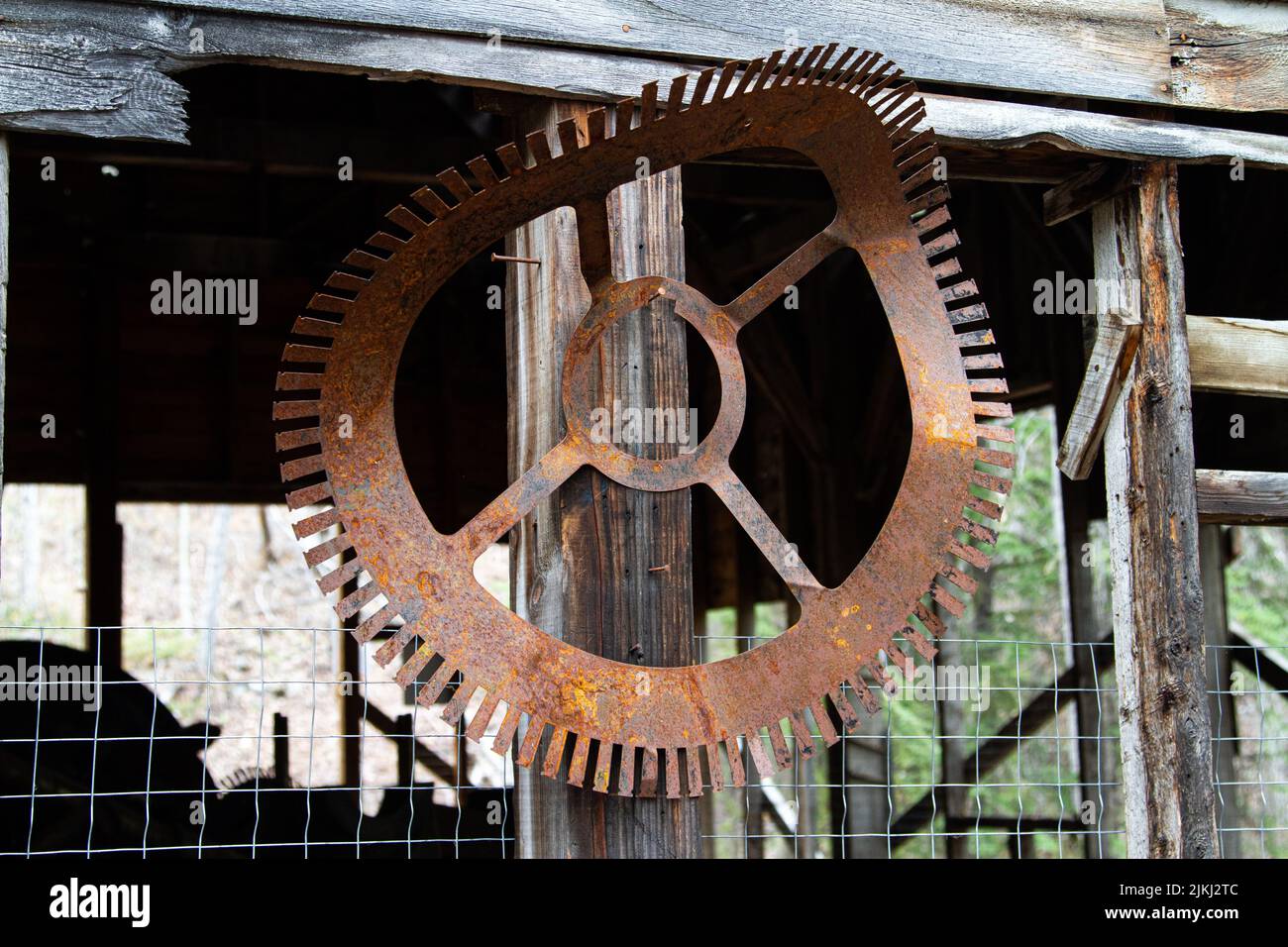 A closeup shot of an old rustic industrial equipment hanging on a wooden column Stock Photo
