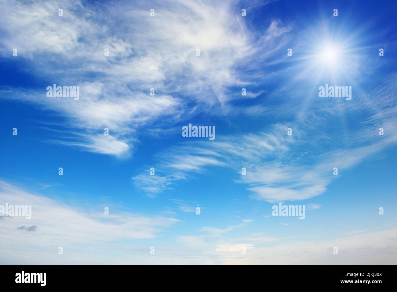 Bright sun on blue sky with white clouds Stock Photo