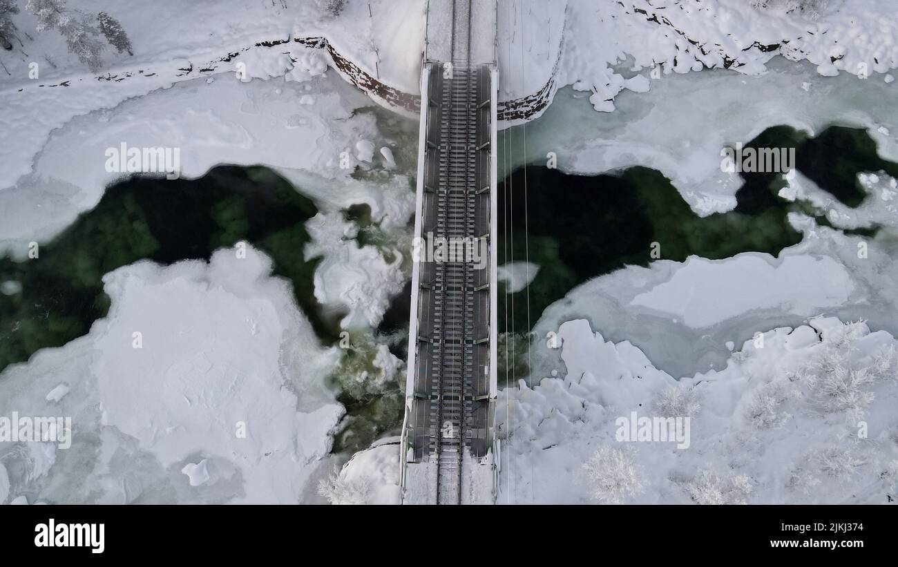 An areal view of a small bridge over the frozen lake all covered by snow Stock Photo