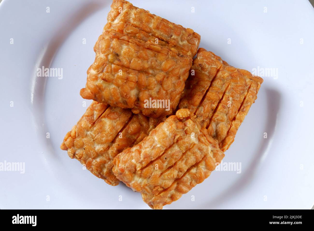 Fried tempeh on a white plate ready to eat, Indonesian food Stock Photo Alamy