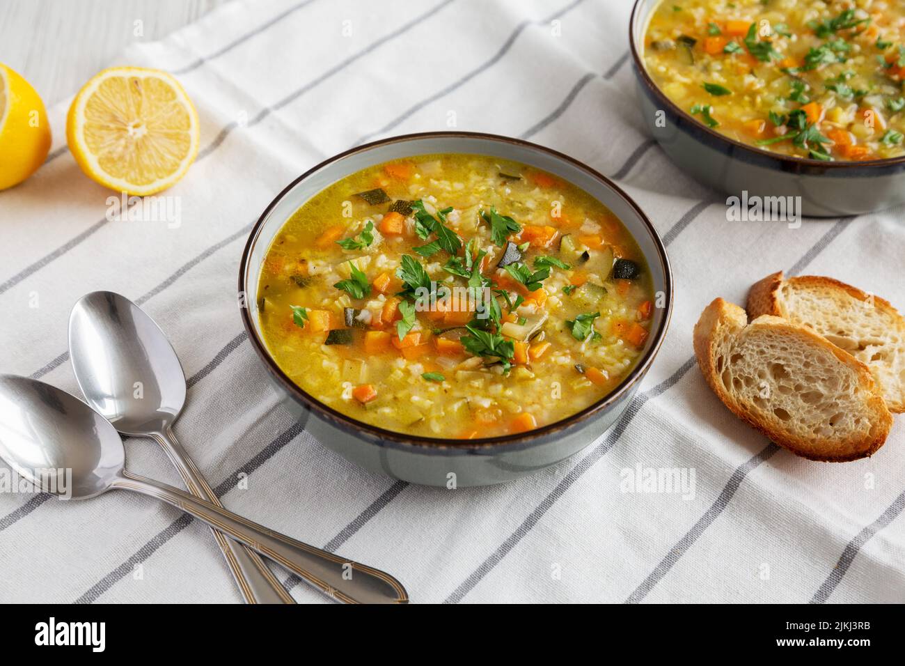 Homemade fresh lemon rice soup in a bowl, side view. Stock Photo