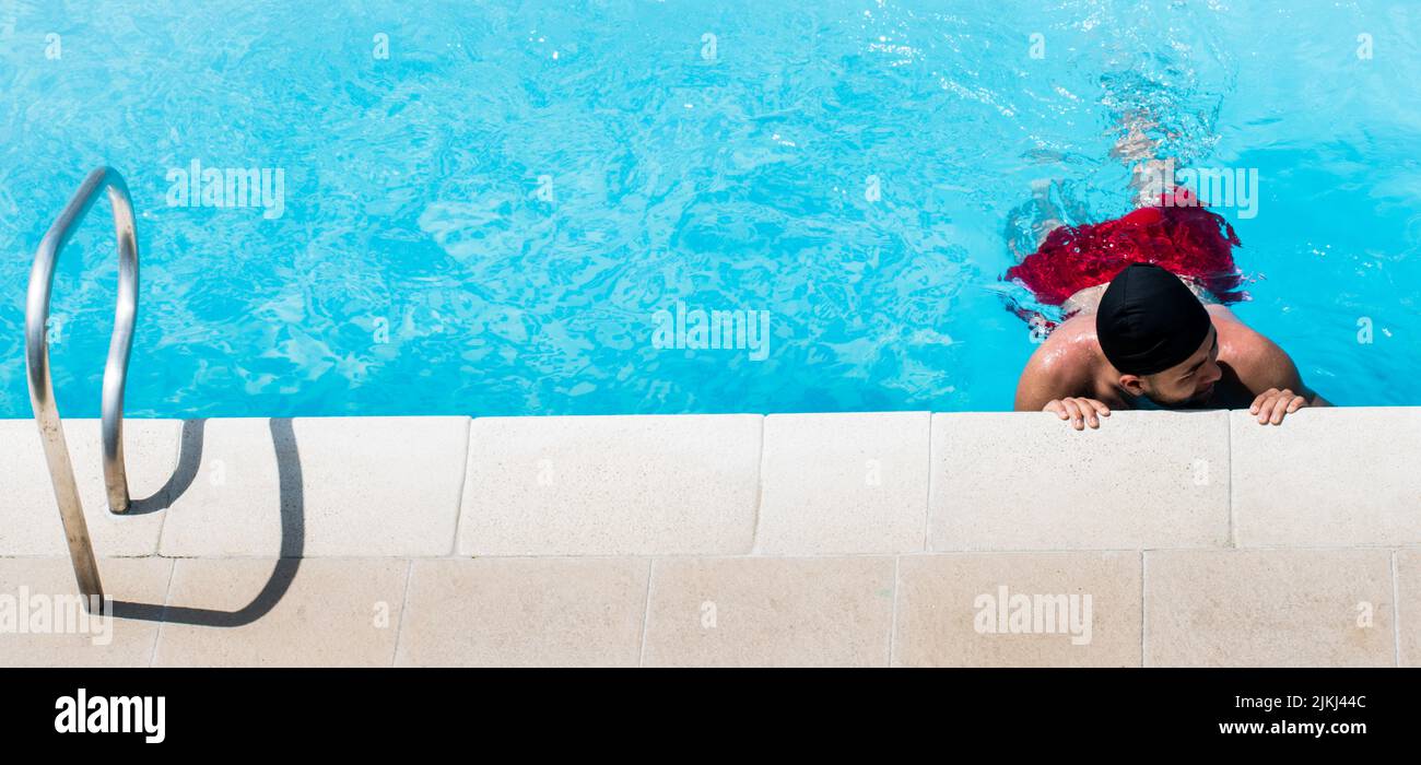 A top view of Hispanic man in the pool on a sunny day in Colombia Stock Photo