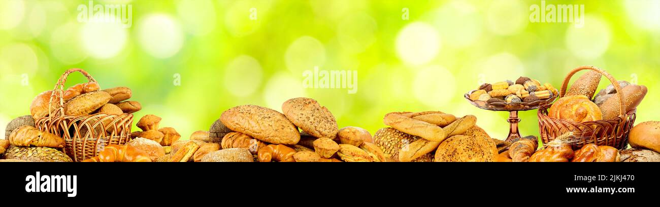 Wide panoramic photo bread products on natural green background. Stock Photo