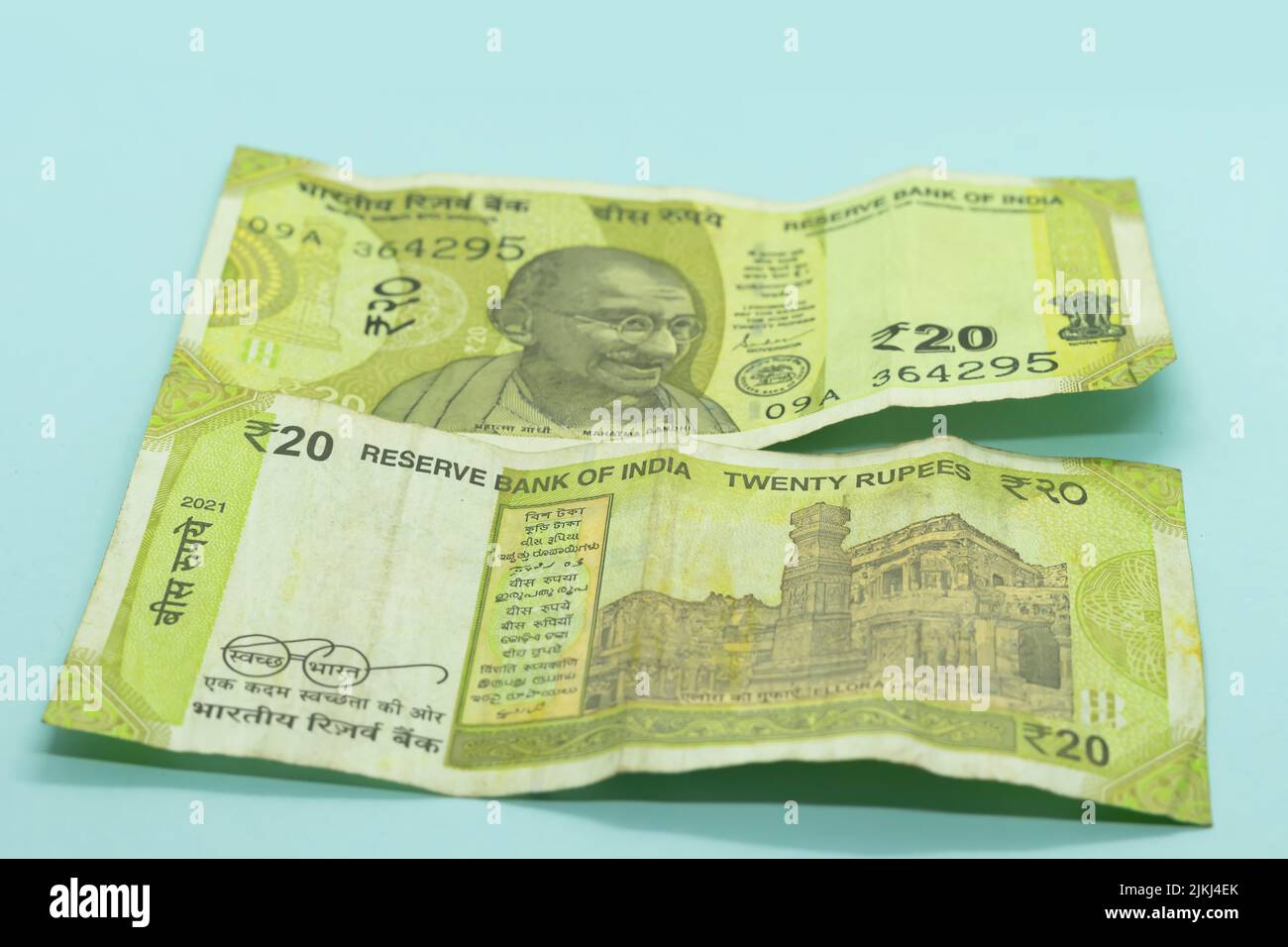 The Indian currency old and new 20 rupee notes on the blue background