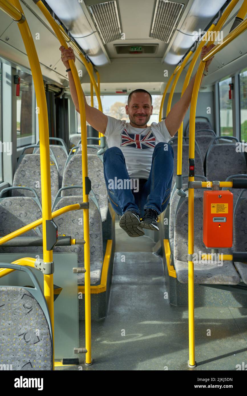 A vertical shot of a male passenger jumping on an empty bus Stock Photo
