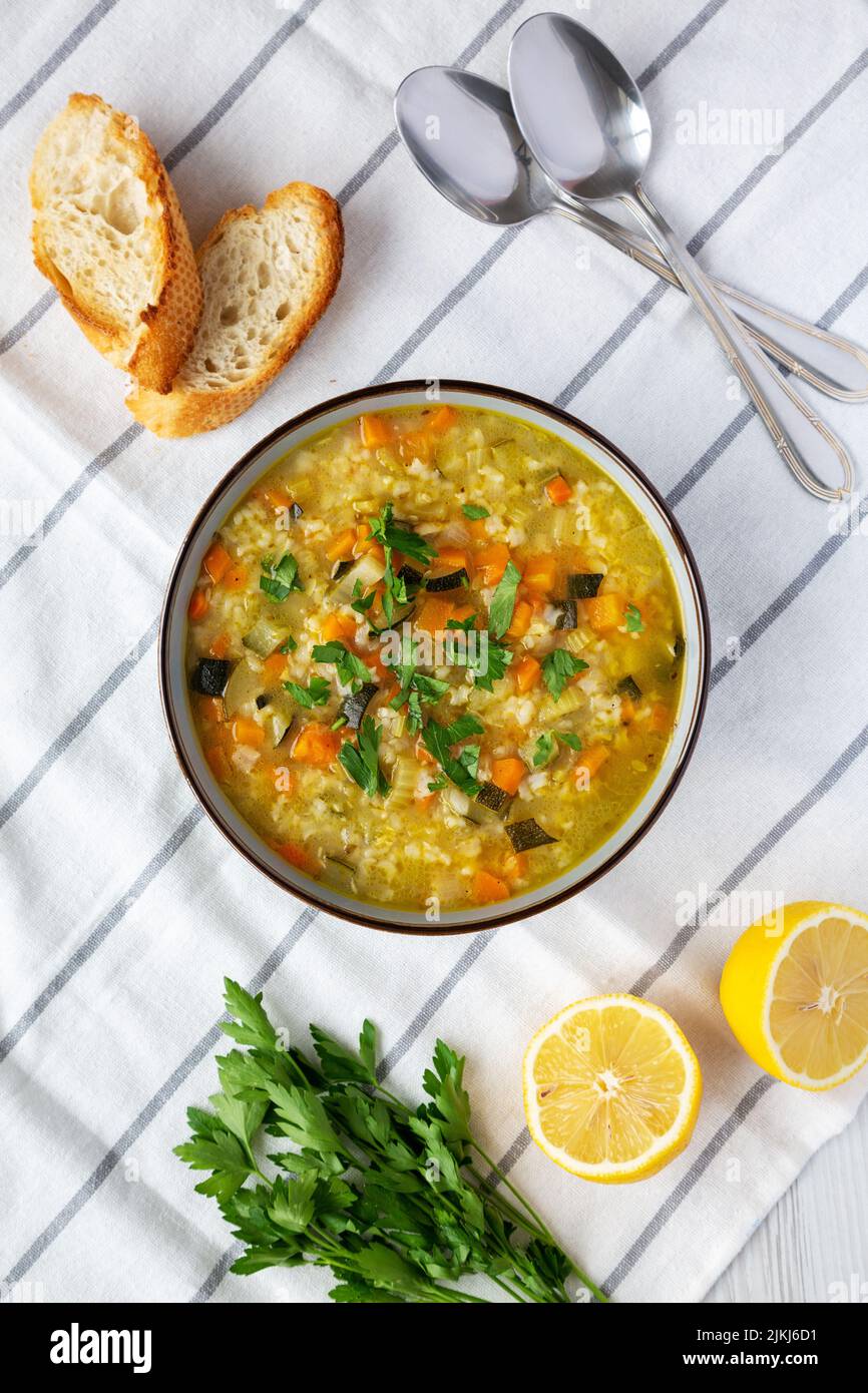 Homemade fresh lemon rice soup in a bowl, top view. Flat lay, overhead, from above. Stock Photo
