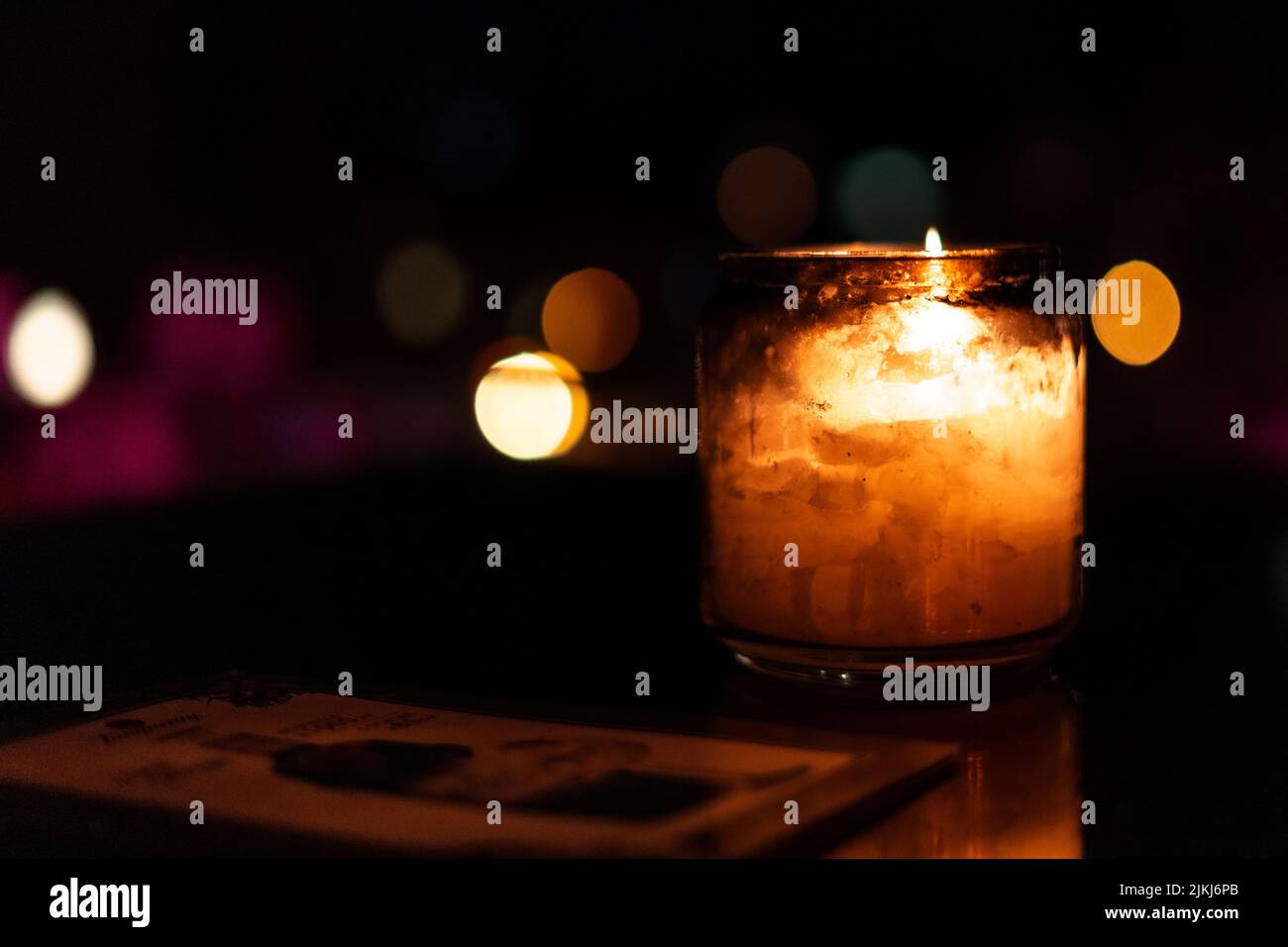 Glass candle with its reflection inside a dark space Stock Photo - Alamy