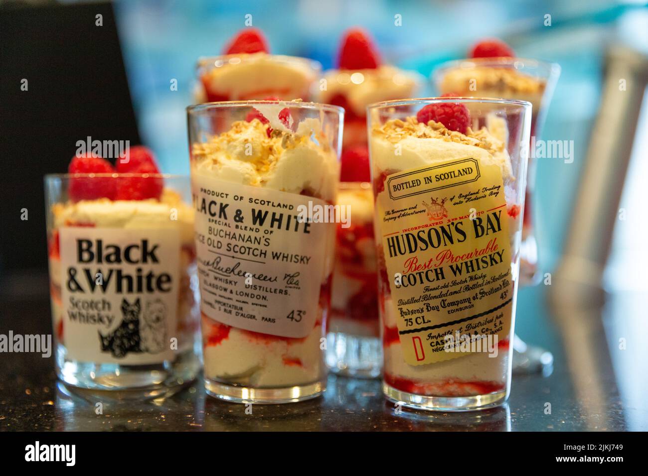 Whiskey shots in glasses with Scottish Shortbread and strawberry cream desserts Stock Photo
