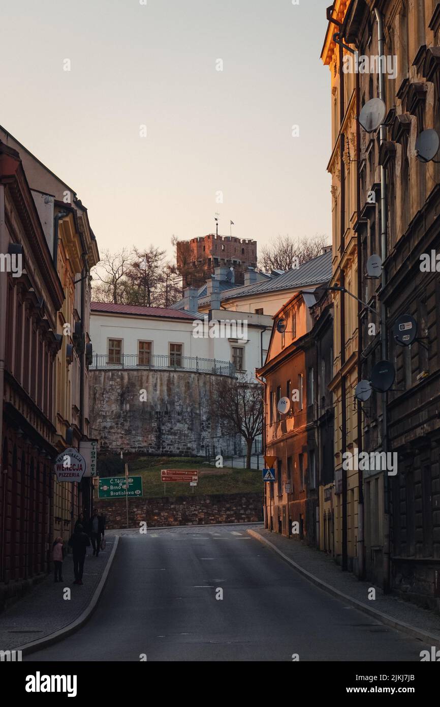 A narrow street in the old town of Cieszyn with a view of a medival tower in the background Stock Photo