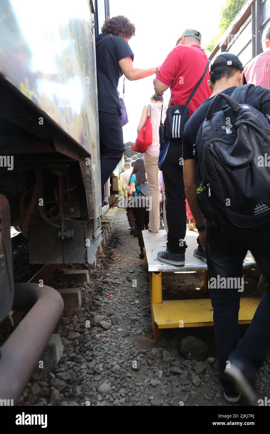 A vertical shot of people in line getting into a train Stock Photo
