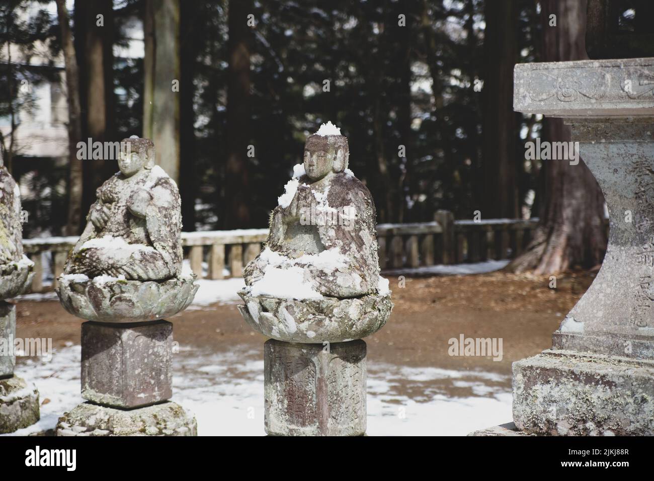 A row of old stone Buddah statues in Japan during winter Stock Photo