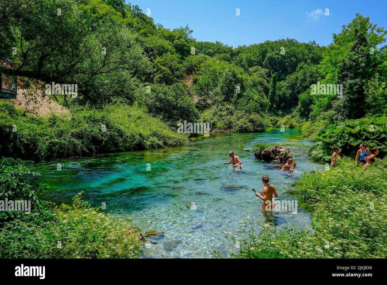 Muzina, Albania - Tourists bathe in Syri i Kaltër, THE BLUE EYE is the country's most abundant water source with 6 ö³/s, located midway between the larger cities of Saranda on the coast and Gjirokastra inland. Stock Photo