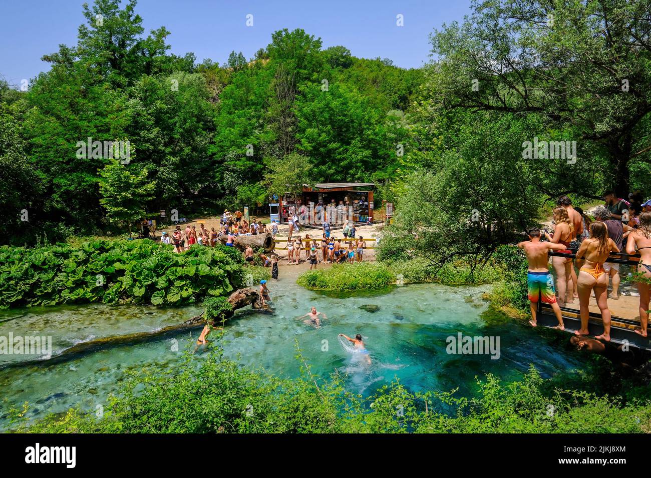 Muzina, Albania - Tourists bathe in Syri i Kaltër, THE BLUE EYE is the country's most abundant water source with 6 ö³/s, located midway between the larger cities of Saranda on the coast and Gjirokastra inland. Stock Photo
