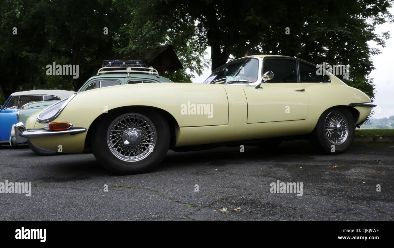 An old vintage yellow Jaguar E-Type parked outdoors Stock Photo