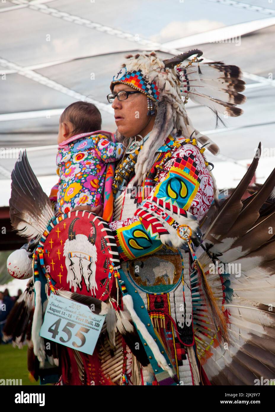 Pow Wow dancer holds baby while dancing at the Shoshone Bannock Pow Wow