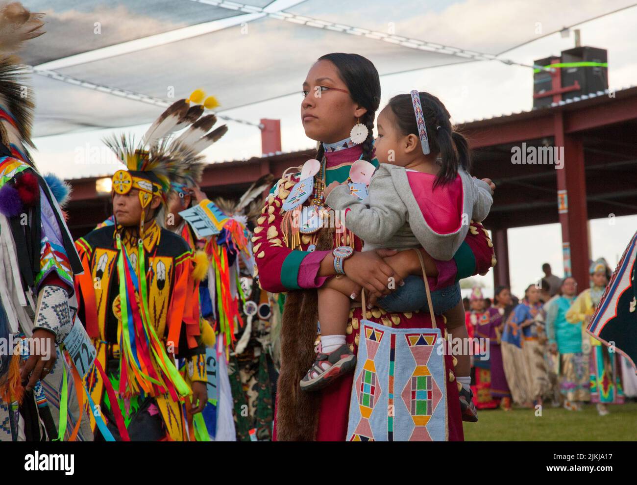 Pow Wow dancer holds baby while dancing at the Shoshone Bannock Pow Wow