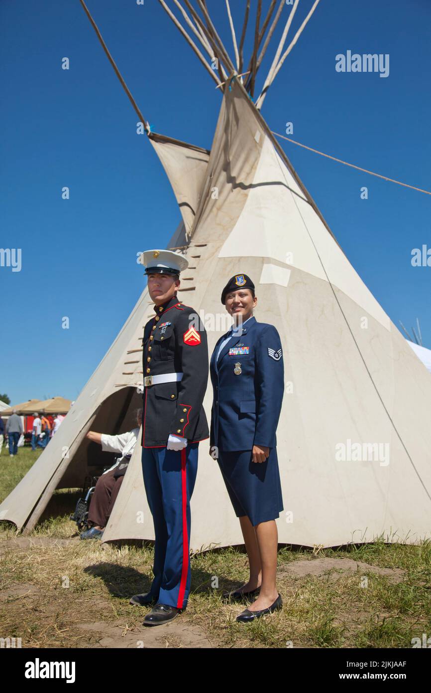 Military family of brother and sister in uniforms stand in front of a