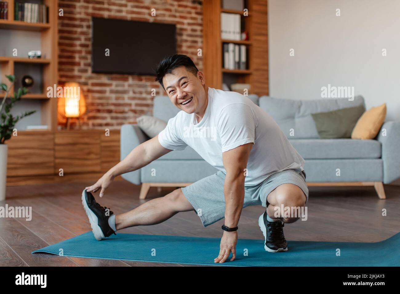 Man stretching leg on floor hi-res stock photography and images - Alamy