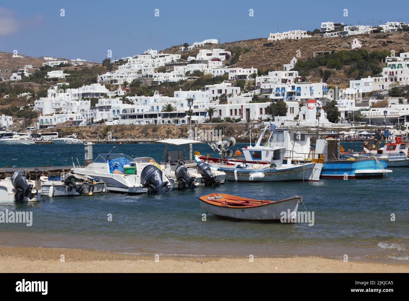 The Mykonos harbor in Greece with small boats in the foreground Stock Photo