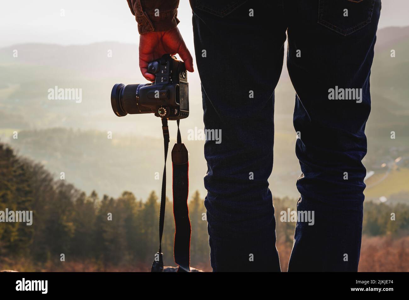 A photographer with a camera at sunset taking photos of a landscape in Bavaria Stock Photo