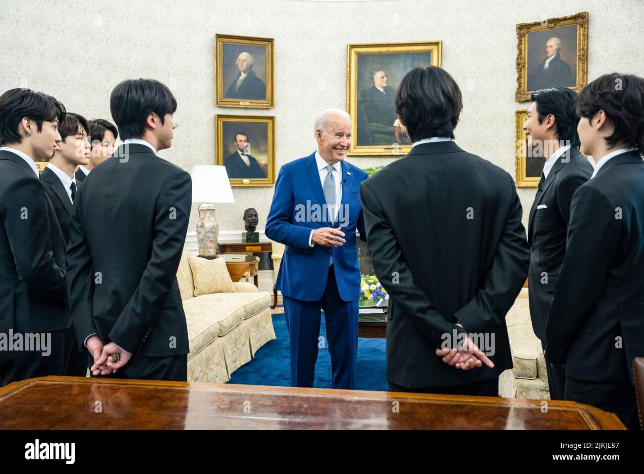 President Joe Biden talks with the K-pop singing group BTS  on Tuesday, May 31, 2022, in the Oval Office of the White House.  (Official White House Photo by Adam Schultz) Stock Photo