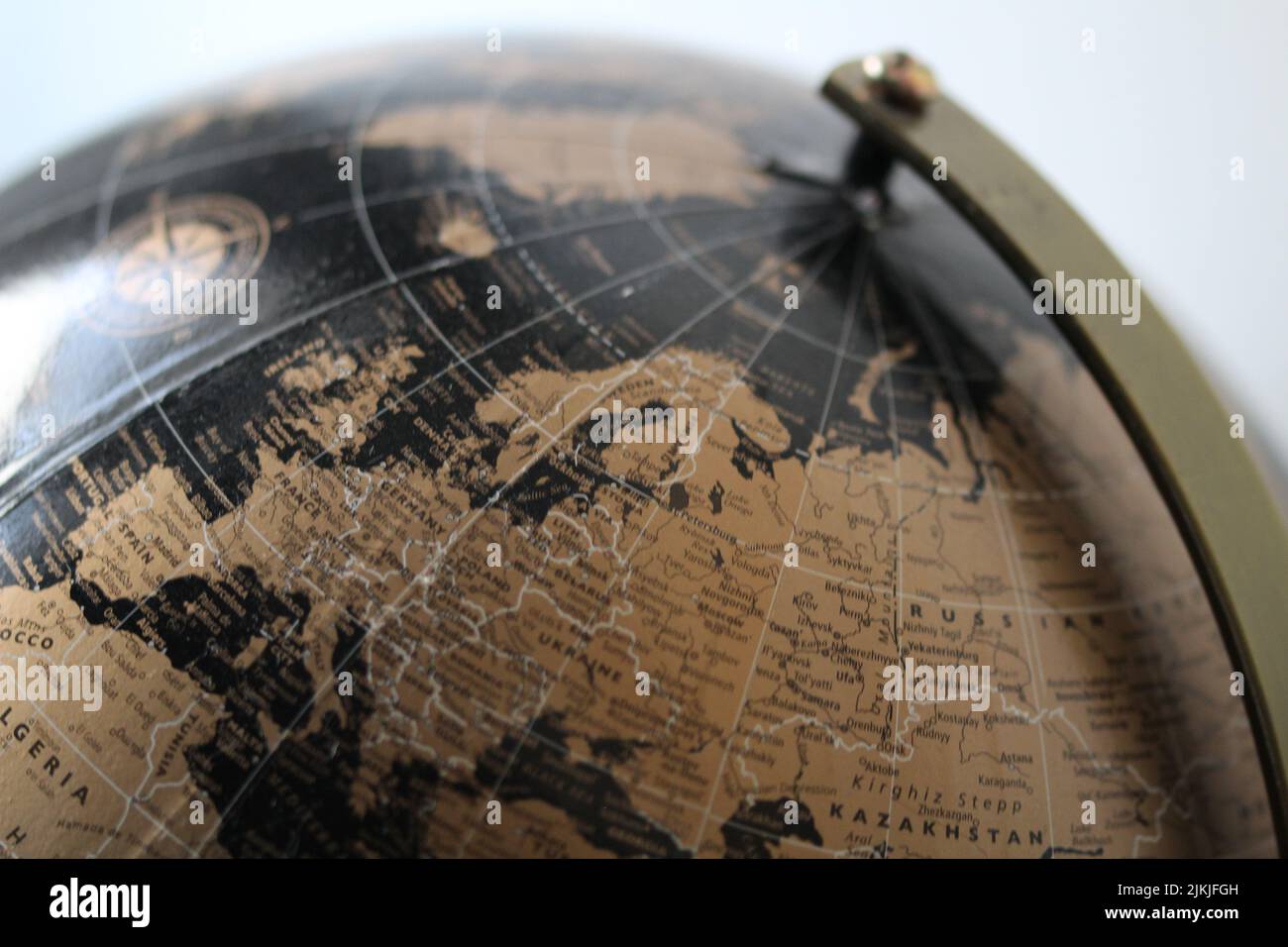 A close-up shot of a black and gold world globe with a blurred background Stock Photo
