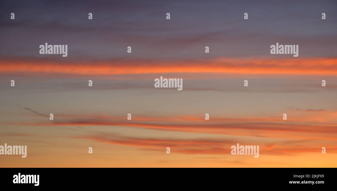 Bright sunset sky, full frame. Orange, pink, red clouds. The sky as a background. Stock Photo