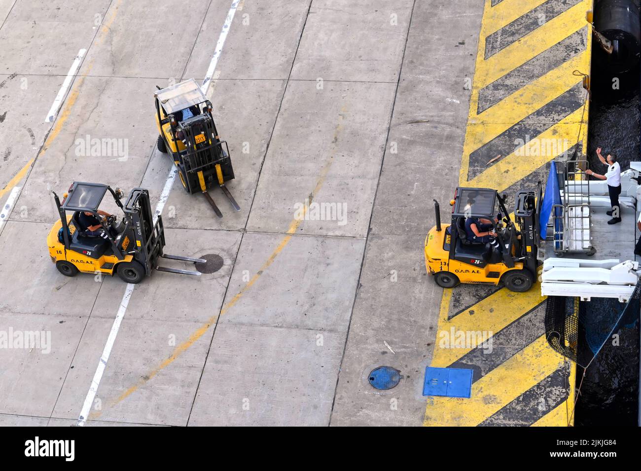 Athens, Greece - may 2022: Aerial view of fork lift trucks on the quayside loading supplies into a cruise ship Stock Photo