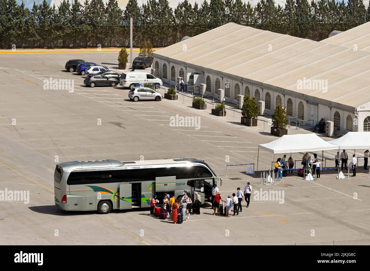 Athens, Greece - may 2022: People collecting luggage from a coach after arriving at one of the city's cruises terminals Stock Photo