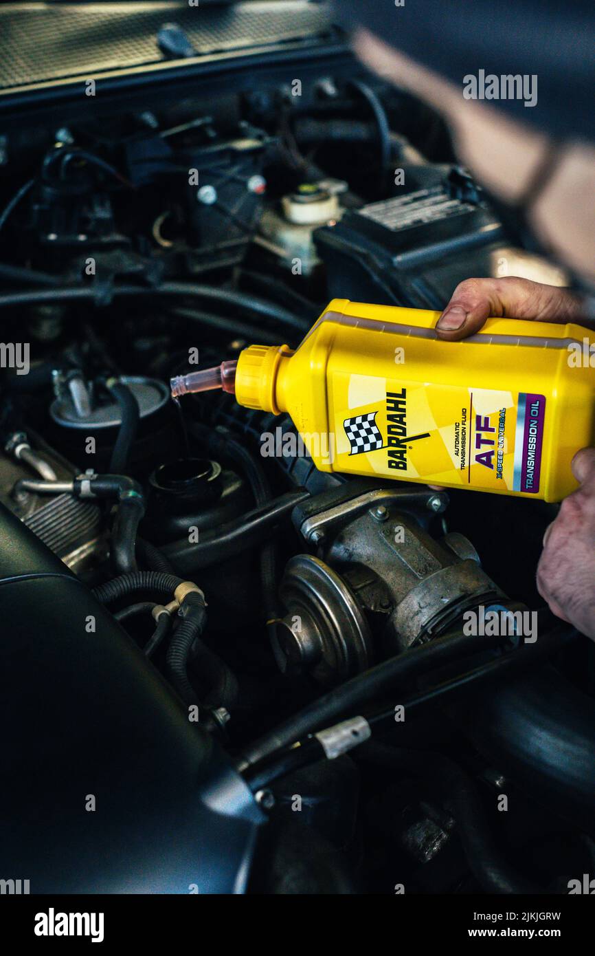 A closeup shot of a car motor oil refilling operation with 'bardahl' oil Stock Photo