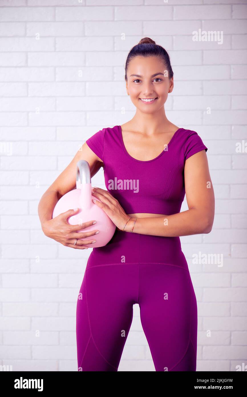 The young Caucasian girl wearing a purple fitness wearing at a gym Stock Photo