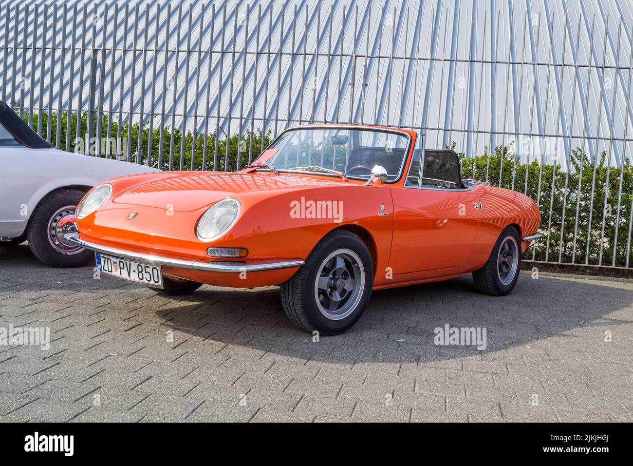 A closeup shot of an orange Fiat 850 sport spider car from the 1970s on a sunny day Stock Photo