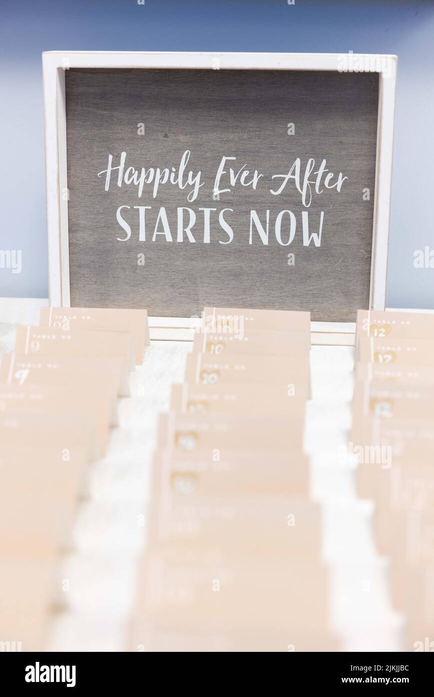A vertical shot of a lines of cards with black board with text 'Happily Ever After STARTS NOW ' on it Stock Photo