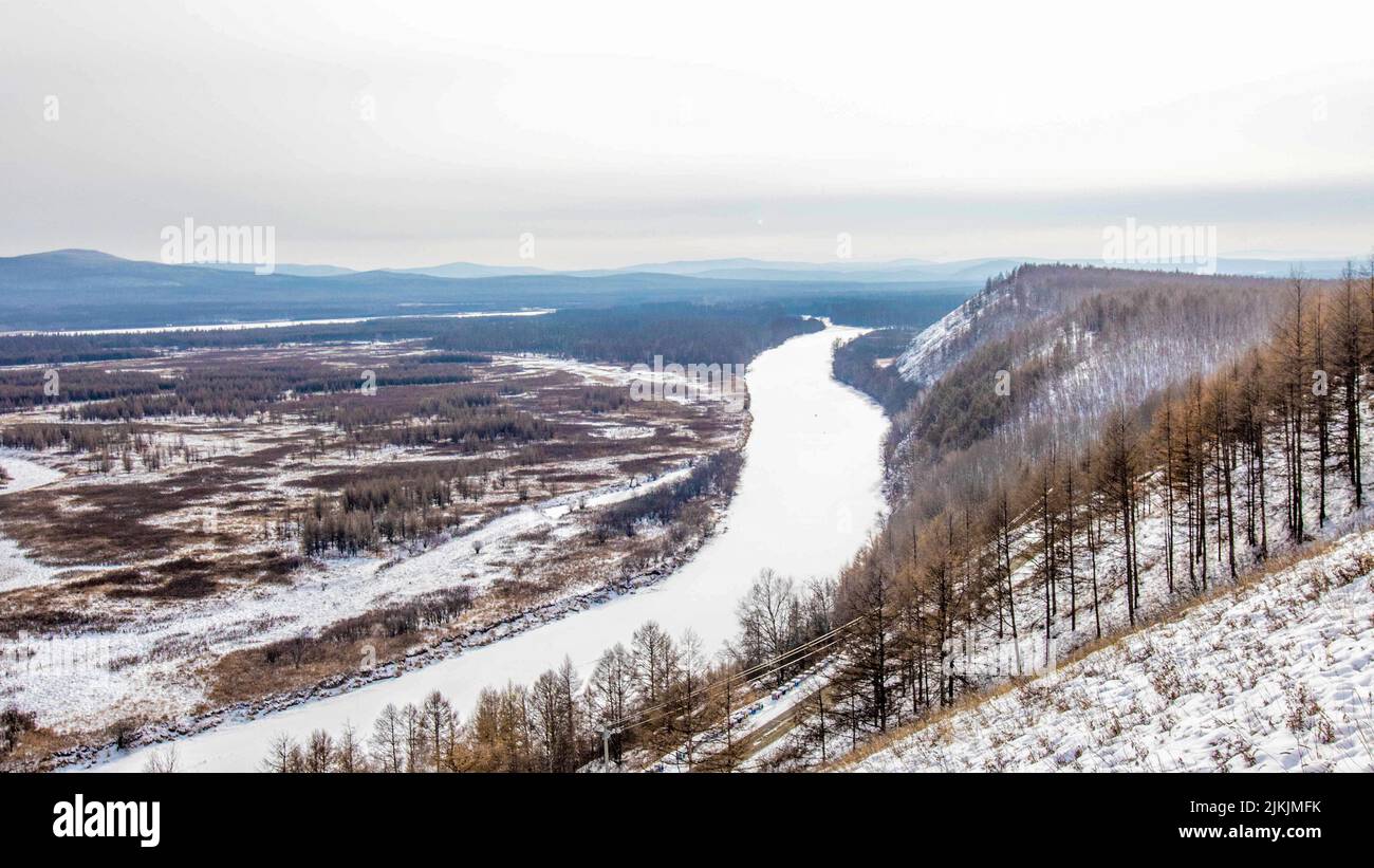 A Bird's-eye view of the snowy valley, forest and frozen river Stock ...
