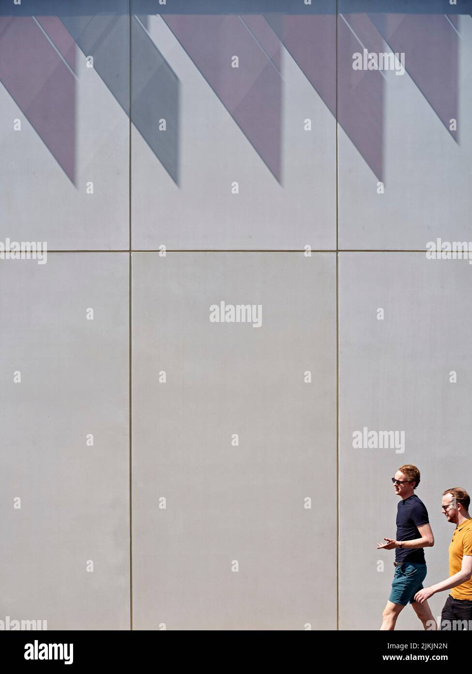 Sun and shadow on exterior facade with passersby. Dorothy Crowfoot Hodgkin Building, Oxford, United Kingdom. Architect: Hawkins Brown Architects LLP, Stock Photo