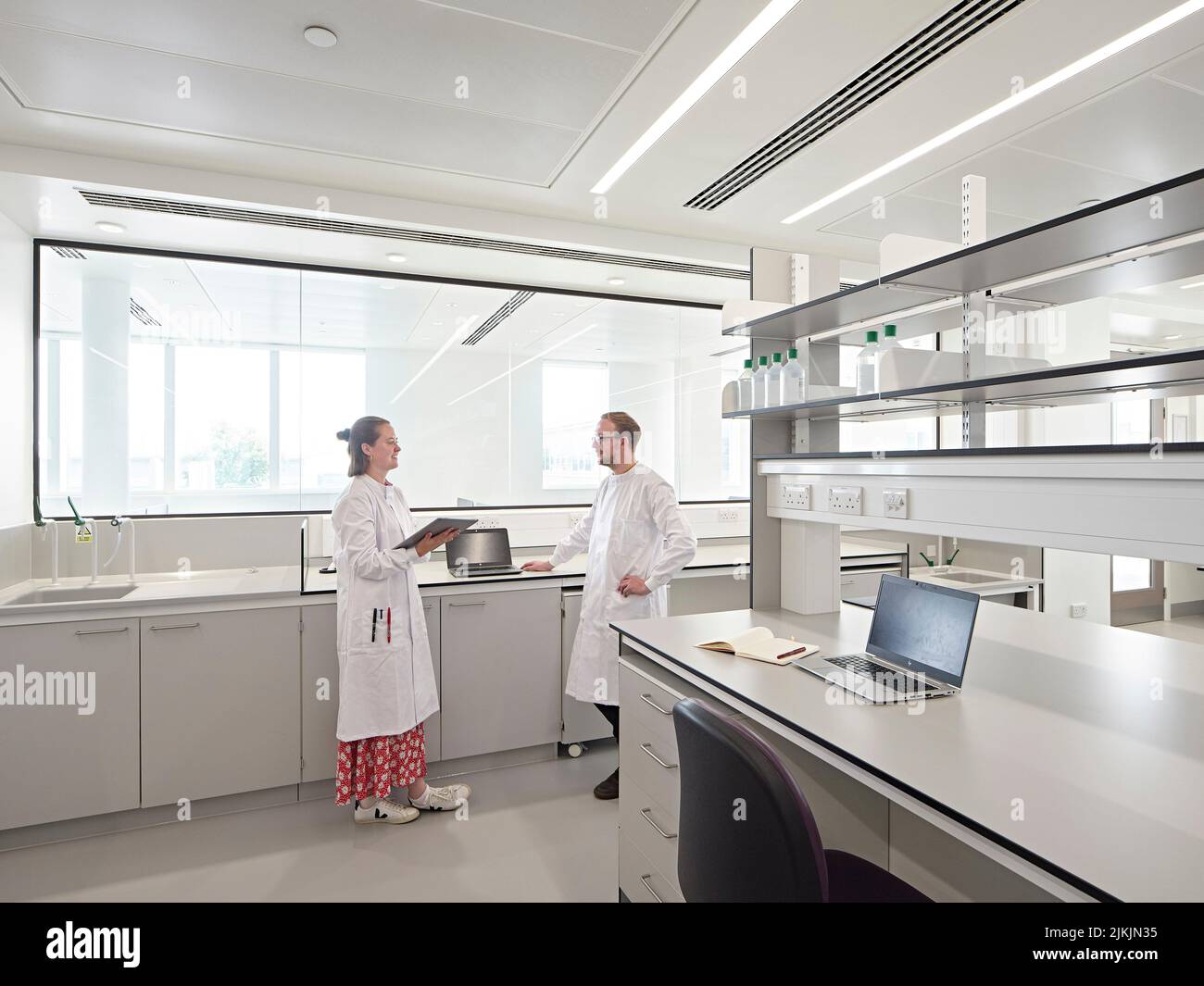 Lab interior with large window and communal workspace. Dorothy Crowfoot Hodgkin Building, Oxford, United Kingdom. Architect: Hawkins Brown Architects Stock Photo