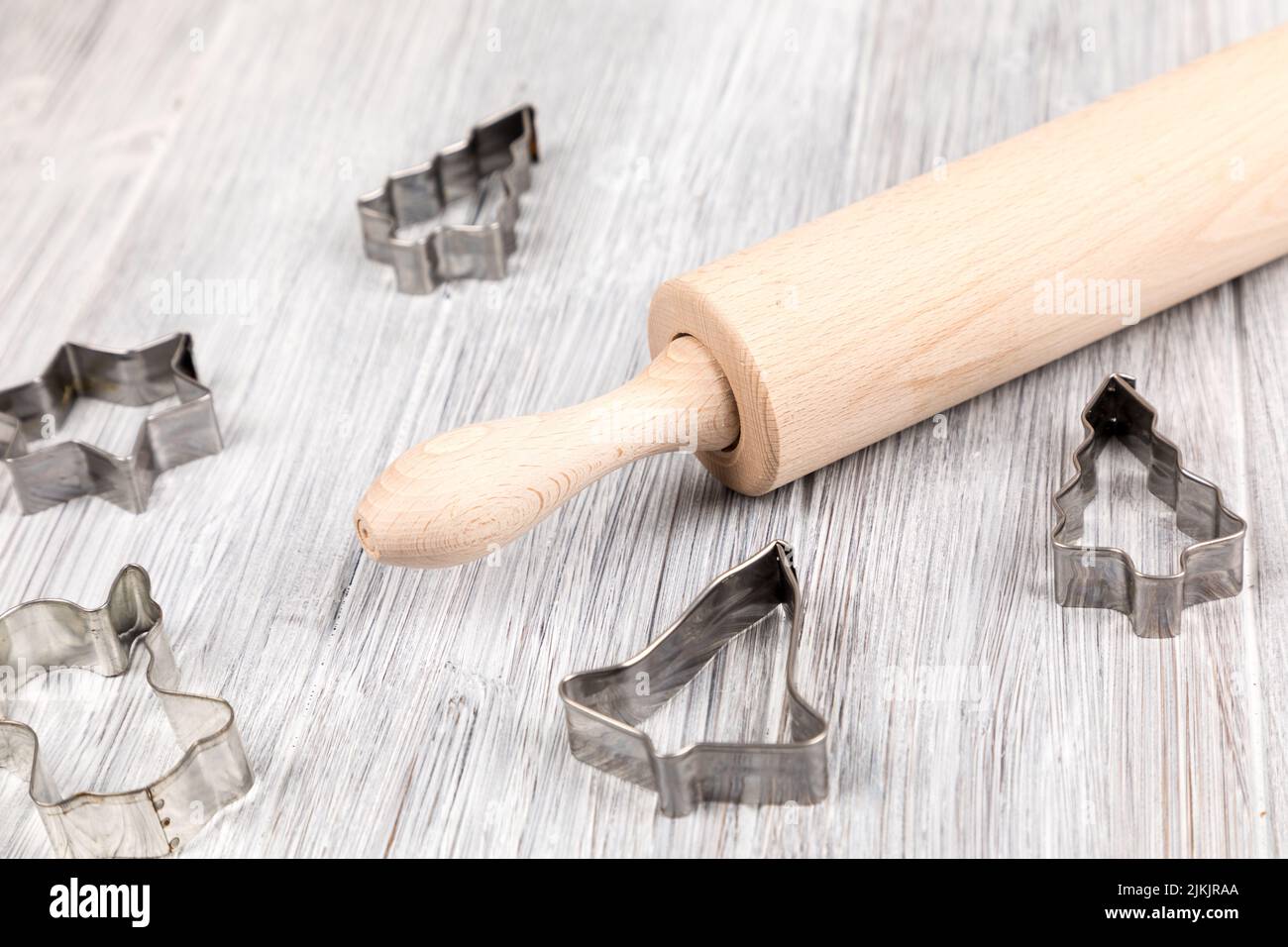 A closeup of a dough roller and cookie cutters for Christmas baking Stock Photo
