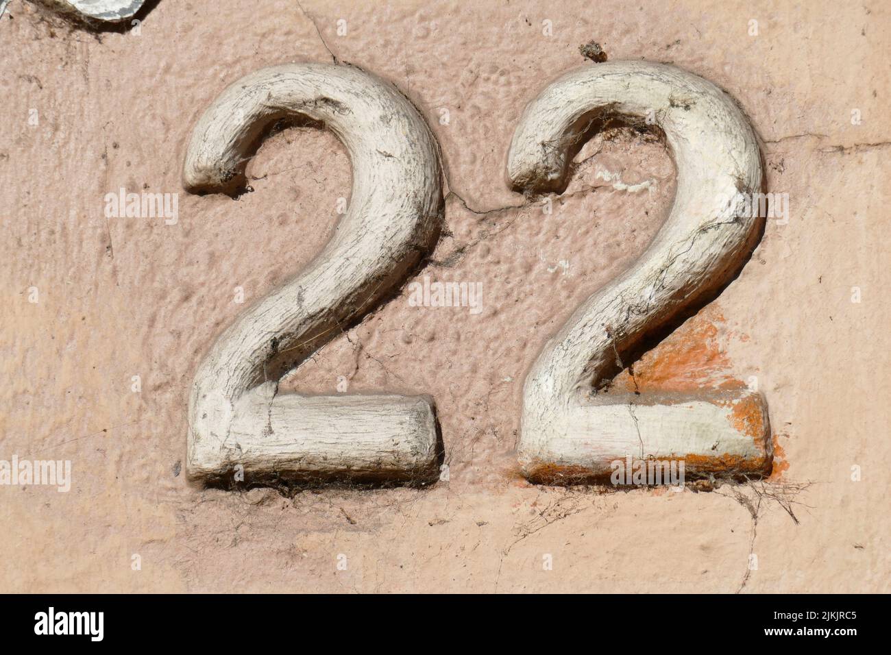 Hausnummernschild Nummer Zweiundzwanzig an einer braunen Hauswand, Deutschland Stock Photo