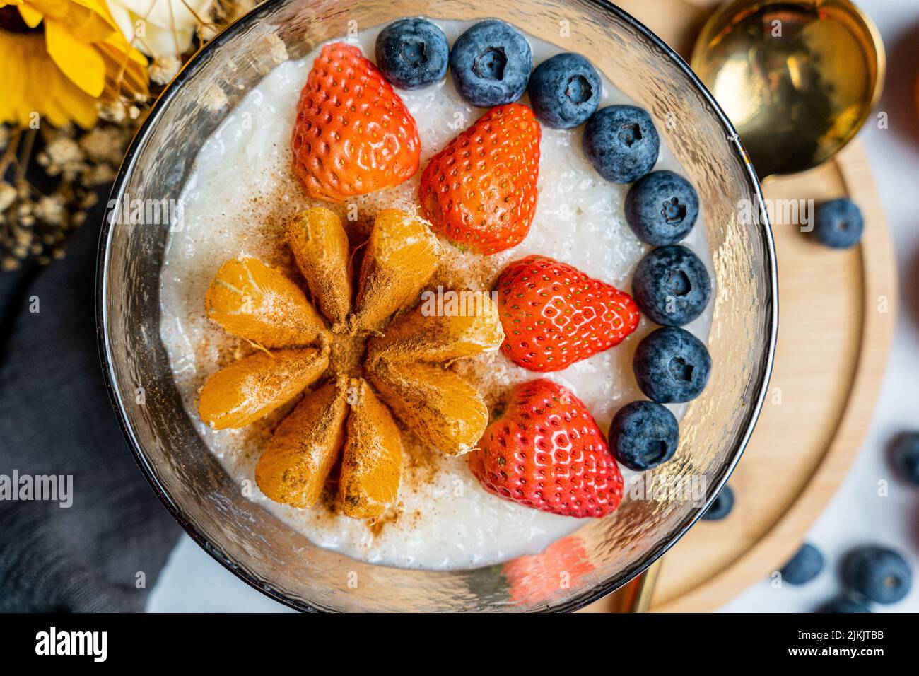 A top view of rice porridge with tangerine, strawberry, blueberry Stock Photo