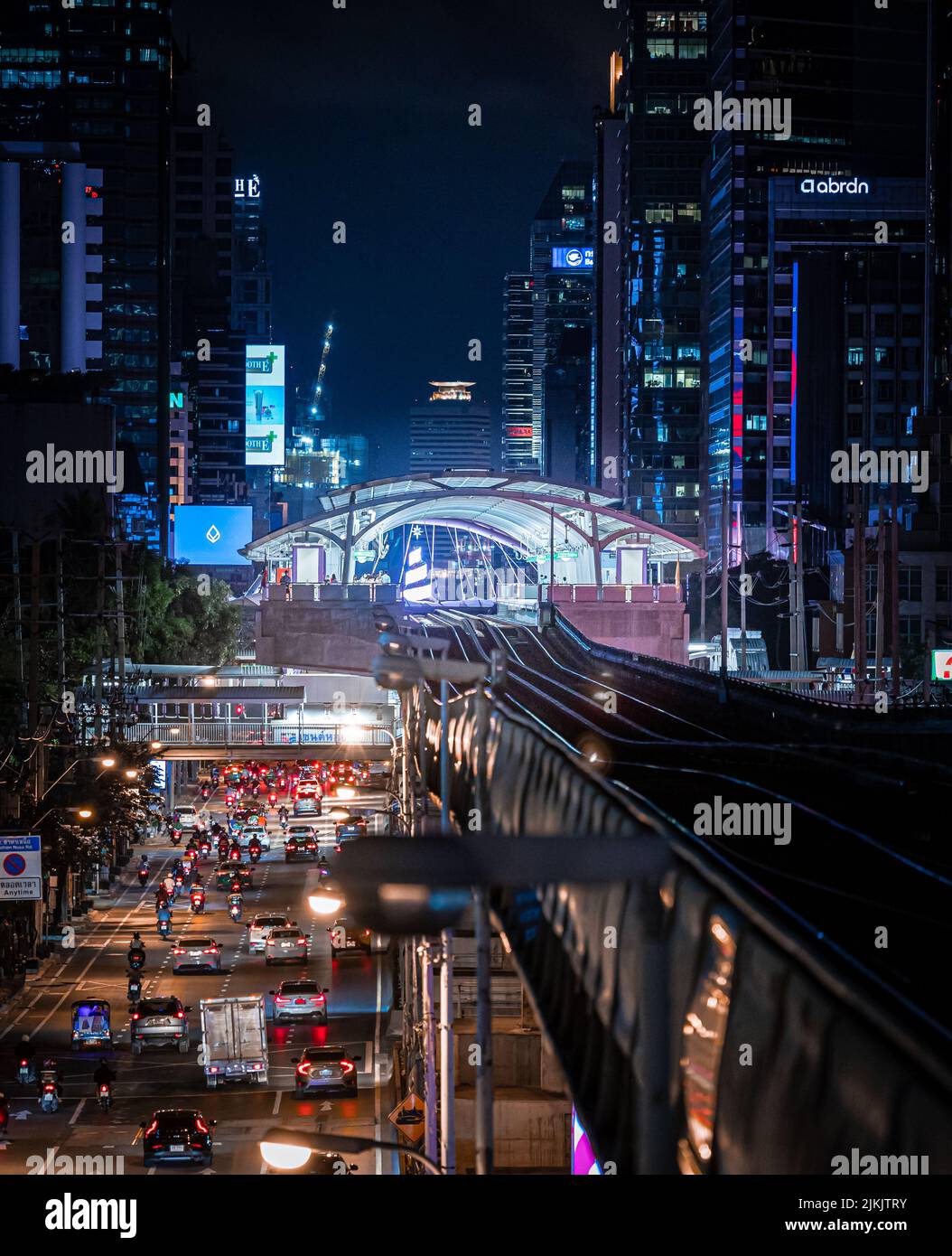 A vertical shot of a night portrait view of a sky train station in downtown Bangkok CBD, Thailand Stock Photo