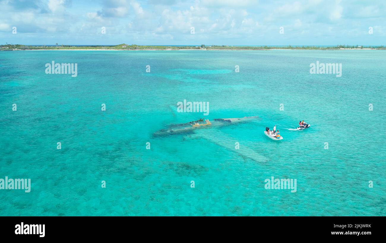 An aerial view of people  in a white tiny boat at Exumas, Bahamas Stock Photo
