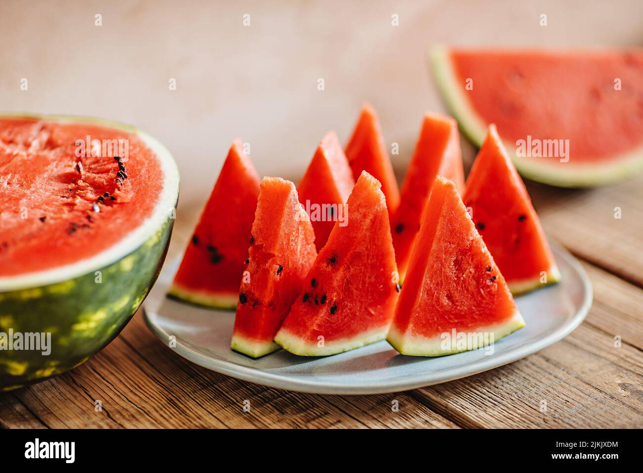 Sliced watermelon on a wooden table in a country house. A shot with a technique of shallow depth of focus Stock Photo