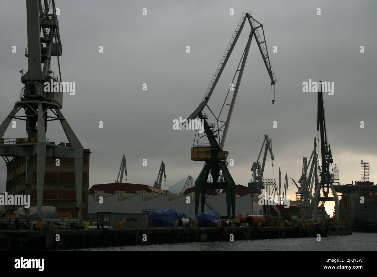 A view of construction cranes against a cloudy sky in the Estuary of ...