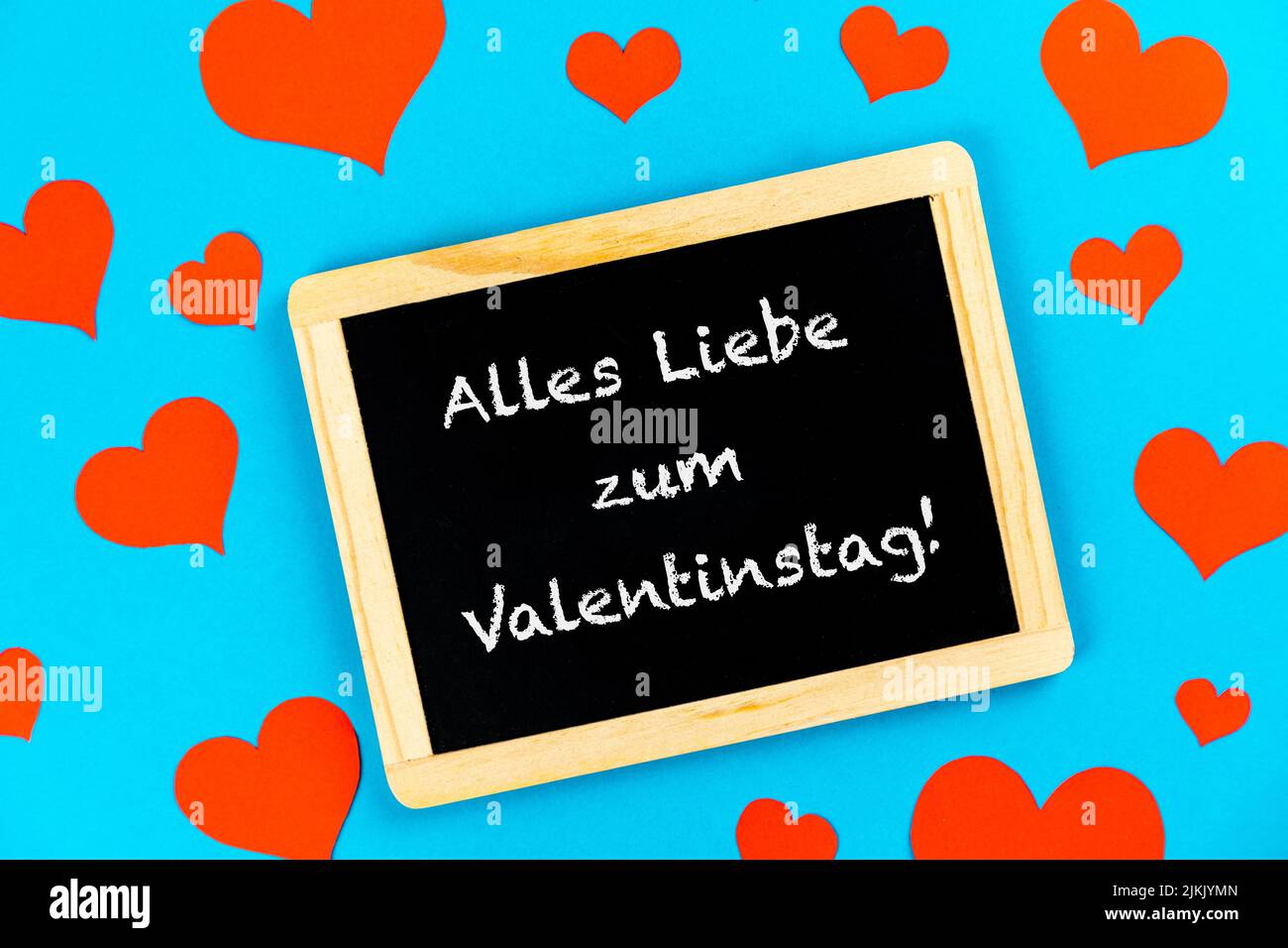 blackboard with red hearts on a blue background with german text alles liebe zum Valentinstag, in english all love for valentines day Stock Photo