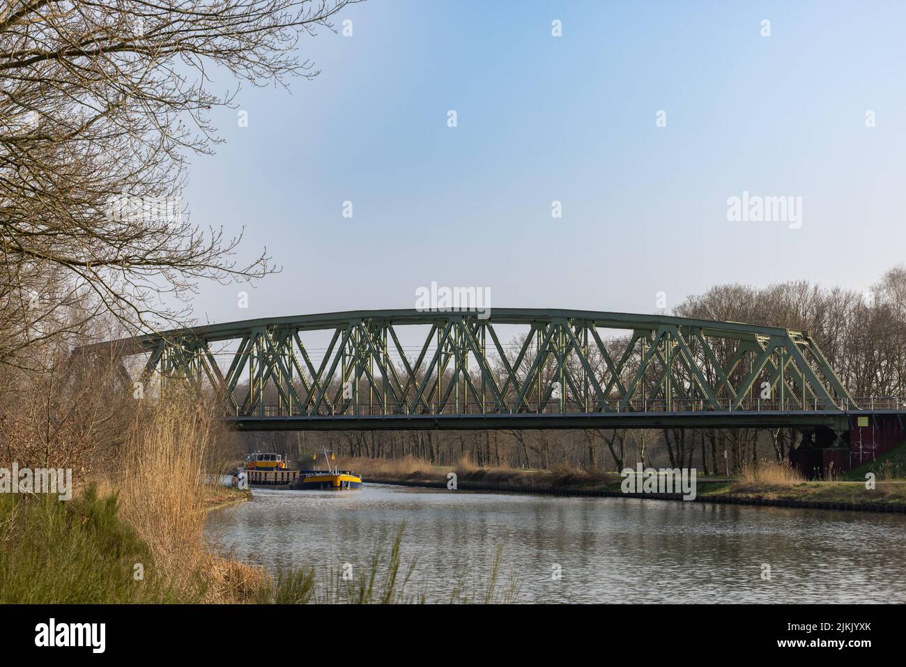 A train bridge over a river in the Netherlands with a canal boat in the background Stock Photo