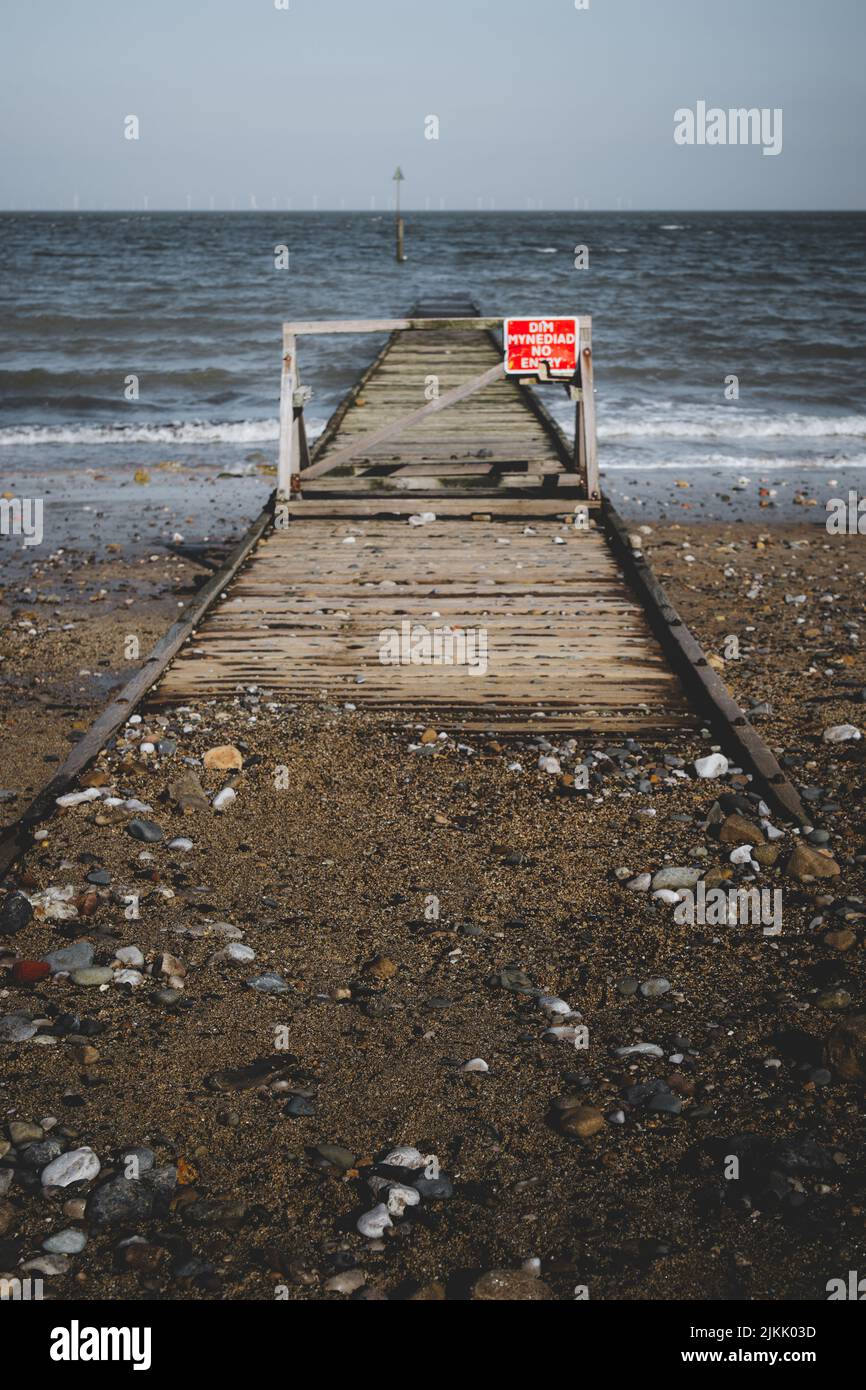 A vertical shot of a do not enter sign on a fence of a dock, written in