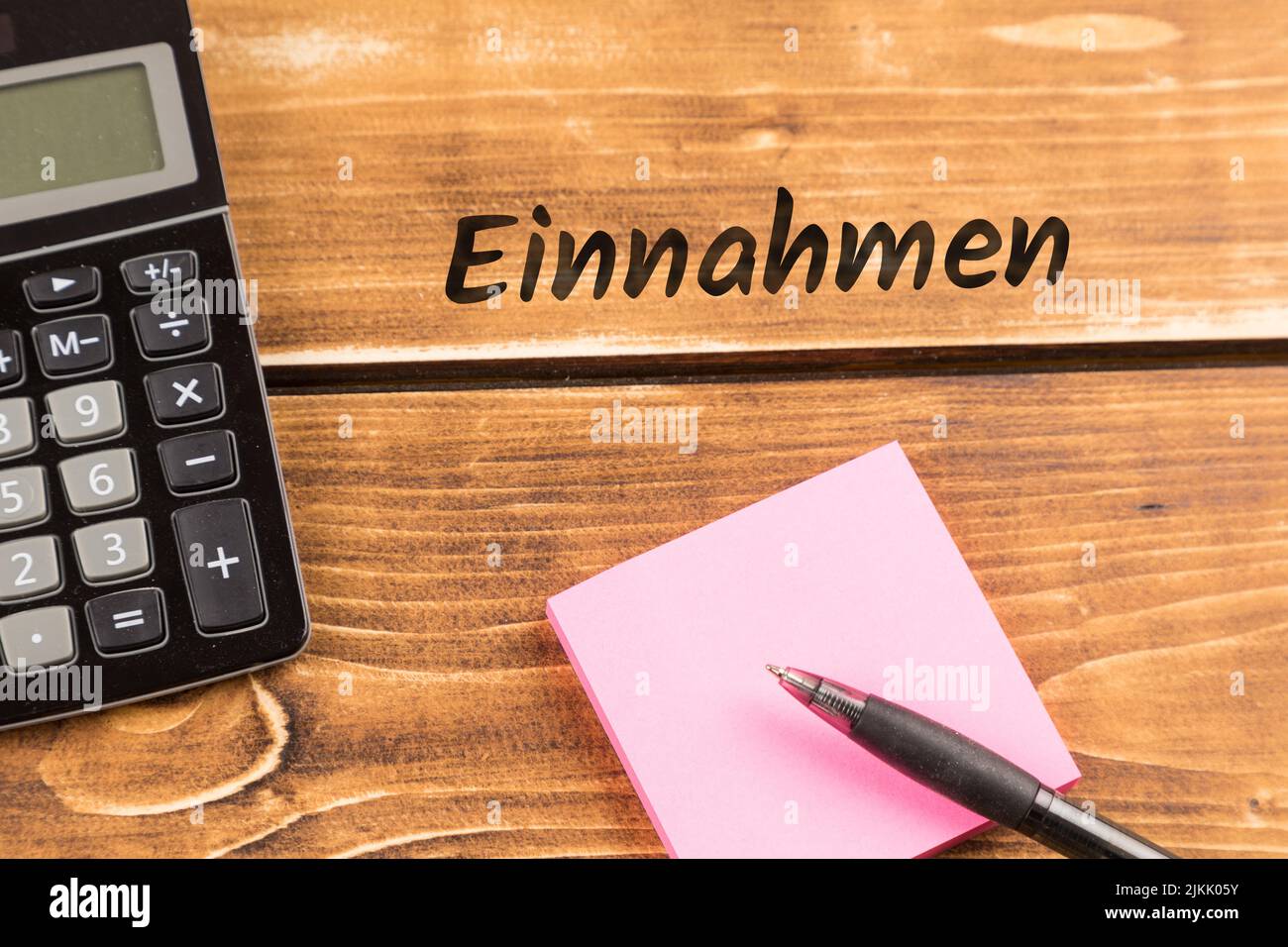 business desk with paper, pen and calculator with german text Einnahmen, in english revenue Stock Photo
