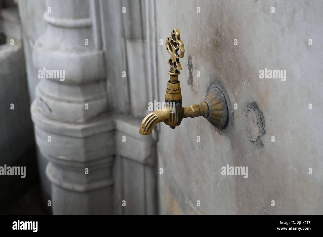 An old faucet on a stone outdoors Stock Photo