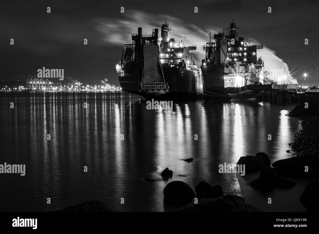 A long exposure night black white photo depicting two large ships at port Stock Photo